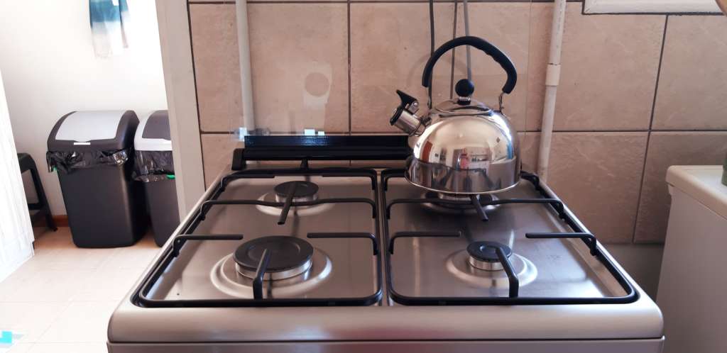 The top of the gas stove, with a kettle on the hob.