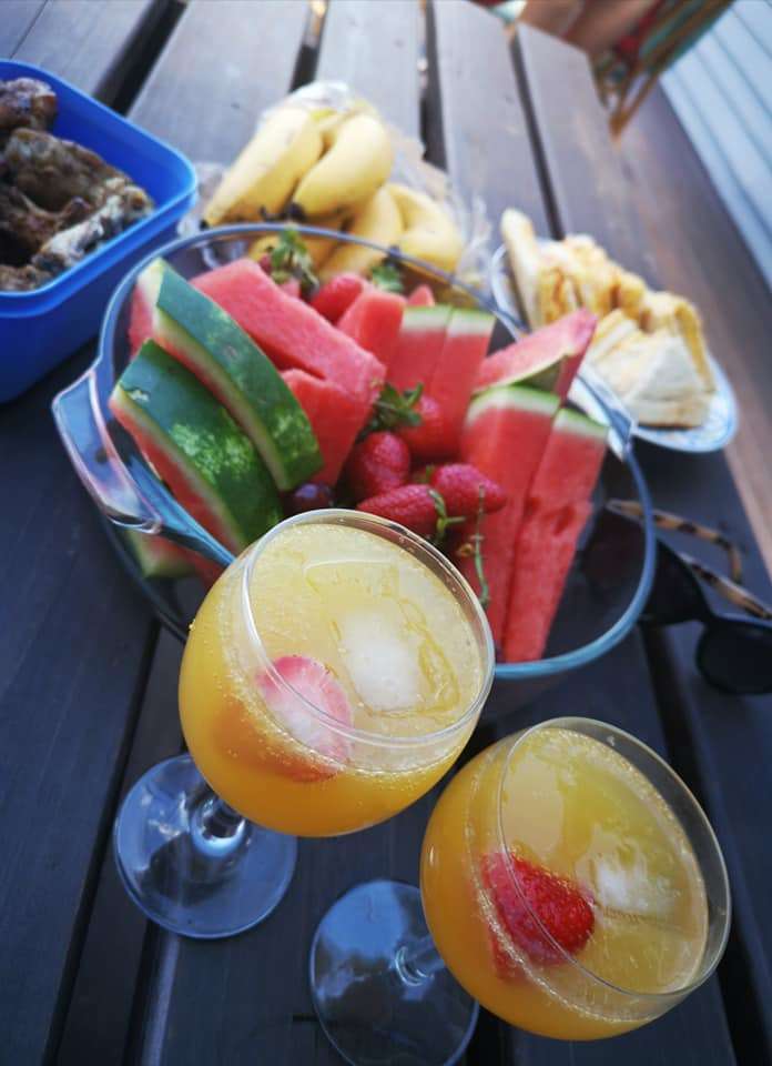 Mimosa drinks, fruit, and sandwiches set out for breakfast on the deck at Fonteintjies.